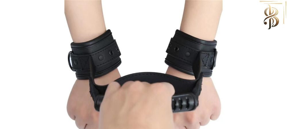 two hands attached with handcuffs and one hand holding the handle.