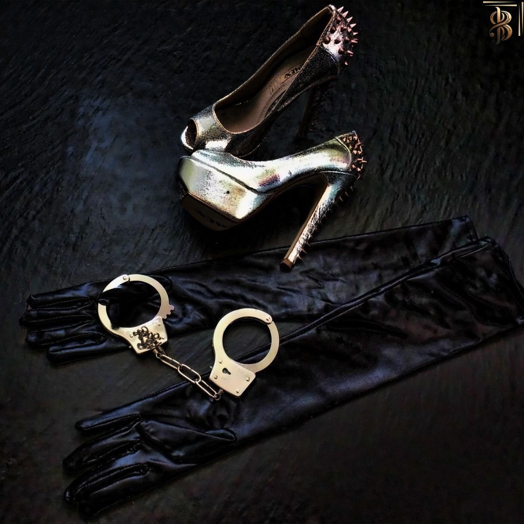 handcuffs, gloves and stiletto heel on the floor representing a woman's costume ensemble